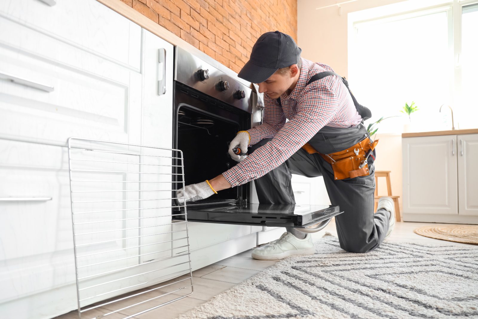 Professional technician installing oven rack in modern kitchen